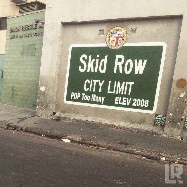 Green Skid Row city limit sign painted on a concrete wall