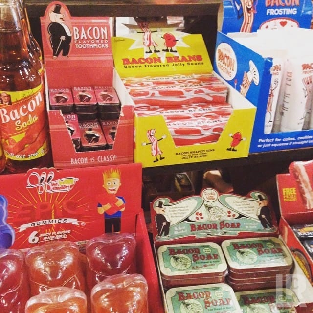 Store shelf display of various novelty bacon-flavored and bacon-scented products in colorful packaging