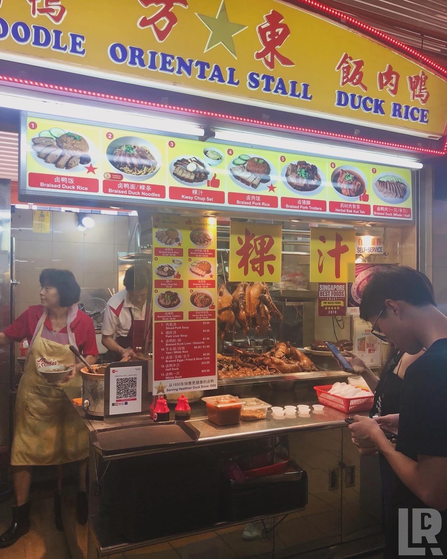 Hawker food stall with roasted duck and noodle dishes on display in Singapore