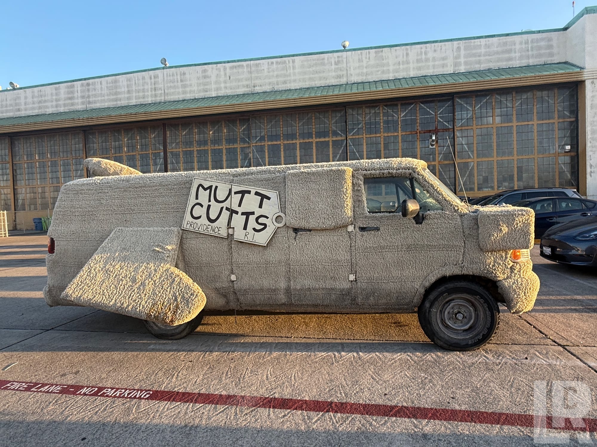 Van covered in fur-like material styled as a dog with a Mutt Cutts sign on the side