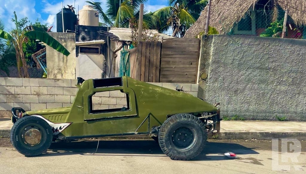 Custom olive green off-road buggy with large tires parked on a street