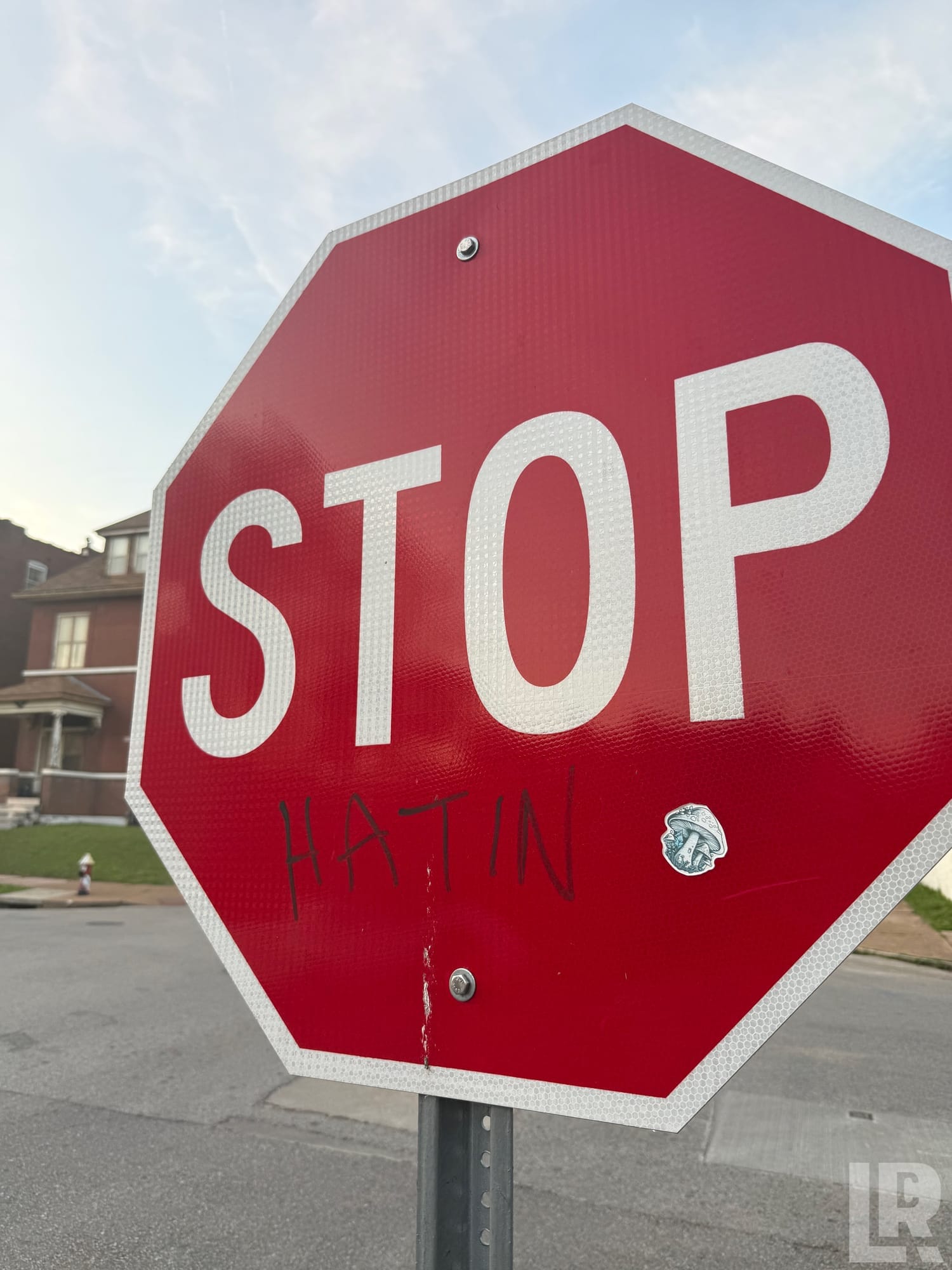 Stop sign with 'HATIN' written in marker below the word STOP