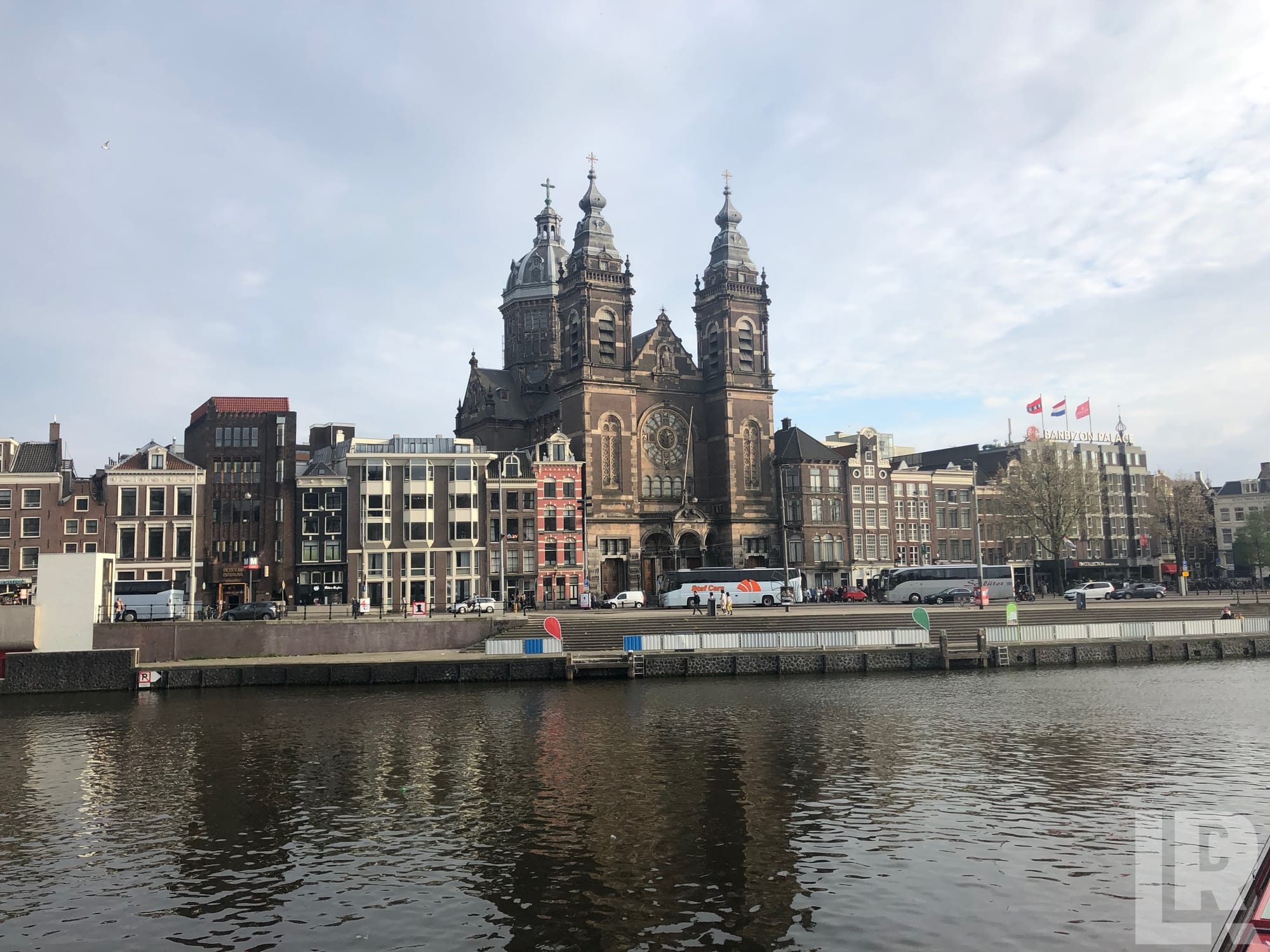 Historic twin-towered church and Dutch canal buildings viewed from across the water