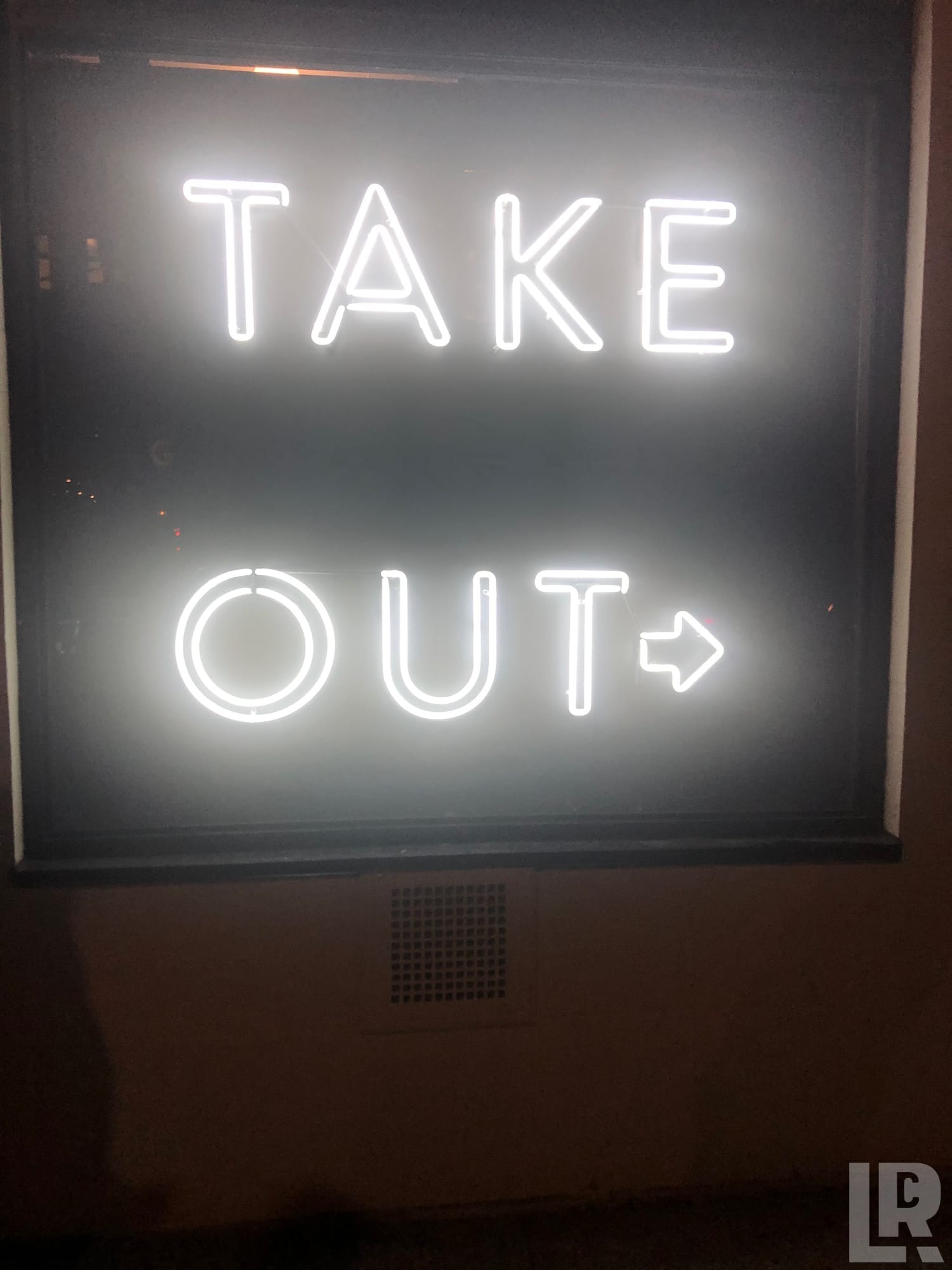 White neon sign saying Take Out with an arrow pointing right