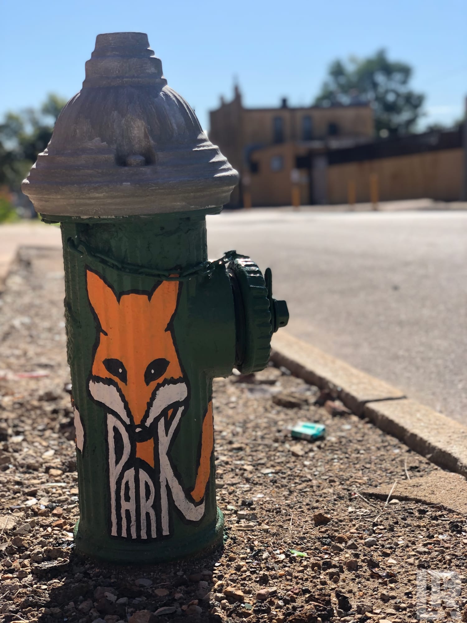 Green fire hydrant decorated with an orange fox illustration and the word PARK
