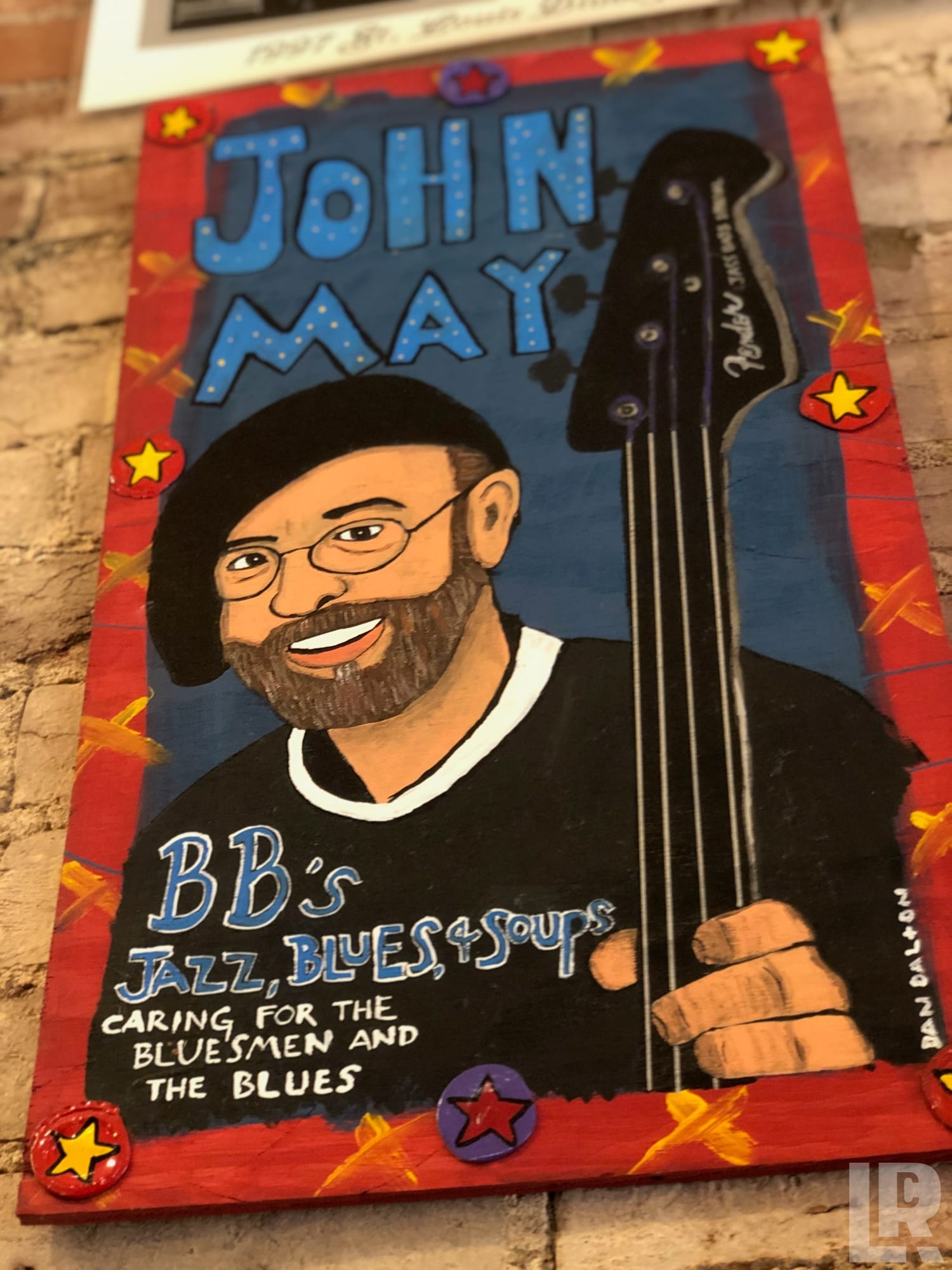 Folk art portrait painting of John May holding a bass guitar, associated with BB's Jazz Blues and Soups